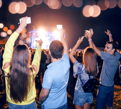 Crowd at an outdoor concert with stage lights